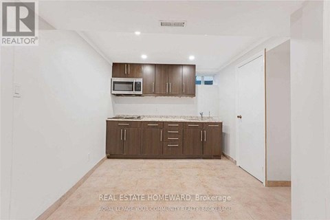 A real estate advertisement showing an empty room with a kitchenette.