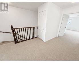 A room with a white door and a carpeted floor.
