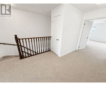 A room with a white door and a carpeted floor.