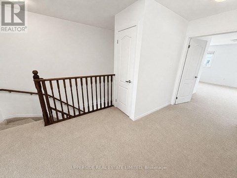 A room with a white door and a carpeted floor.