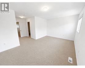 A spacious, empty room with a carpeted floor and white walls.