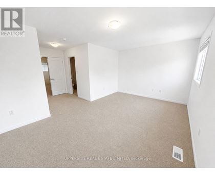 A spacious, empty room with a carpeted floor and white walls.