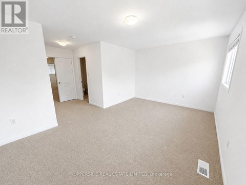 A spacious, empty room with a carpeted floor and white walls.