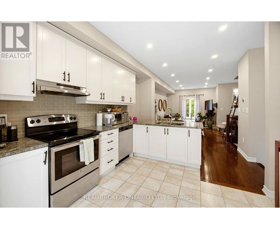 A kitchen with white cabinets and a stove top oven.