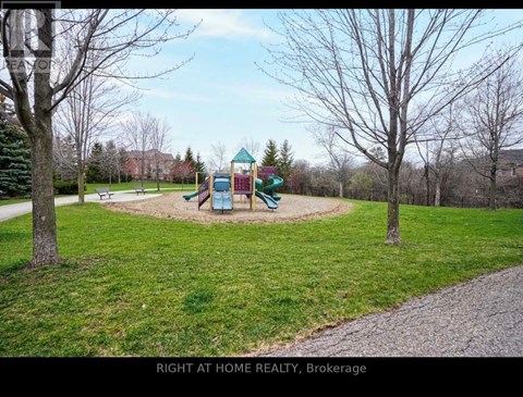 A playground in a park with a slide and a green and red structure.