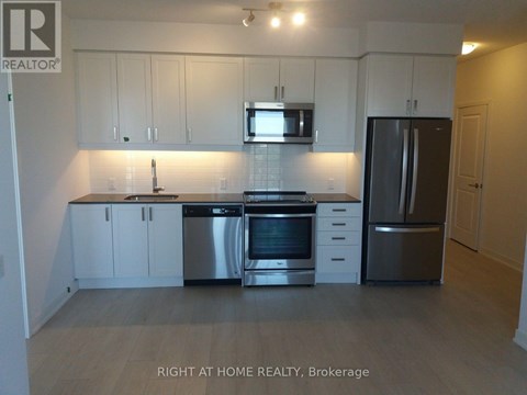 A kitchen with white cabinets and stainless steel appliances.