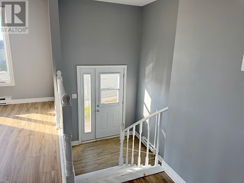 A room with a white door and a staircase.