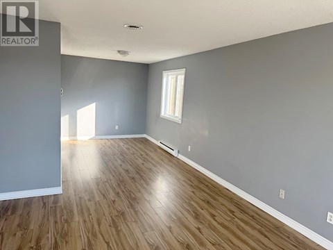 A room with wooden flooring and a window.