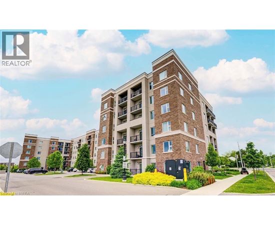 A large brick apartment building with a parking lot in front.