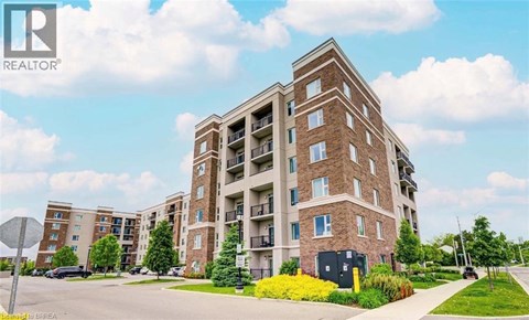 A large brick apartment building with a parking lot in front.