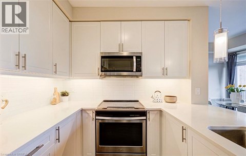A modern kitchen with a stove top oven in the center.