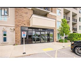 A black car is parked in a parking lot in front of a building with a sign that says REALTOR.