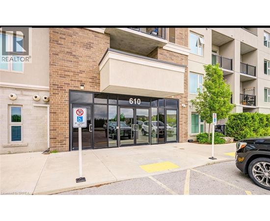 A black car is parked in a parking lot in front of a building with a sign that says REALTOR.