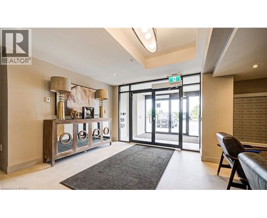 A well-lit room with a grey rug and a wooden cabinet with glass doors.