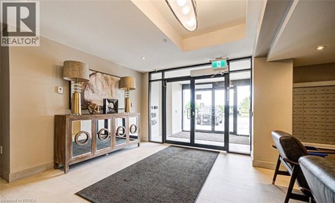 A well-lit room with a grey rug and a wooden cabinet with glass doors.
