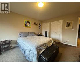 A bedroom with a bed, nightstand, and a painting on the wall.