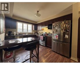 A kitchen with a table and chairs in the foreground and a refrigerator covered in magnets in the background.