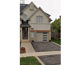 A house with a garage and a driveway in front of it.