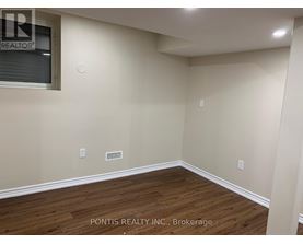 A room with wooden flooring and a window showing the word REALTOR.
