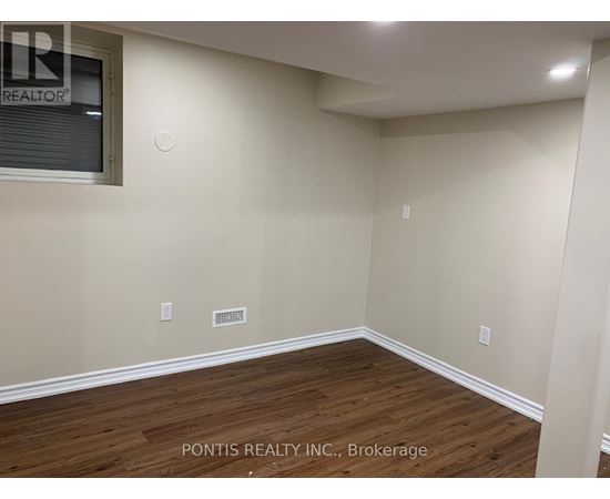 A room with wooden flooring and a window showing the word REALTOR.