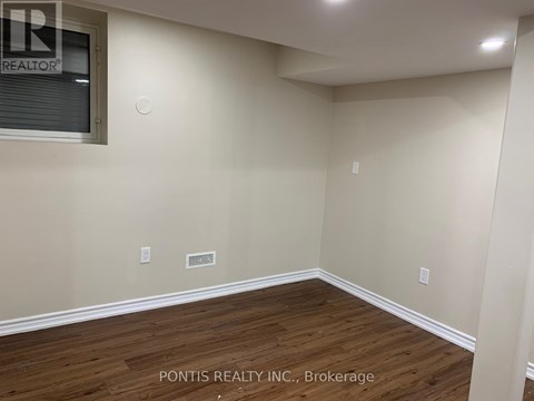 A room with wooden flooring and a window showing the word REALTOR.