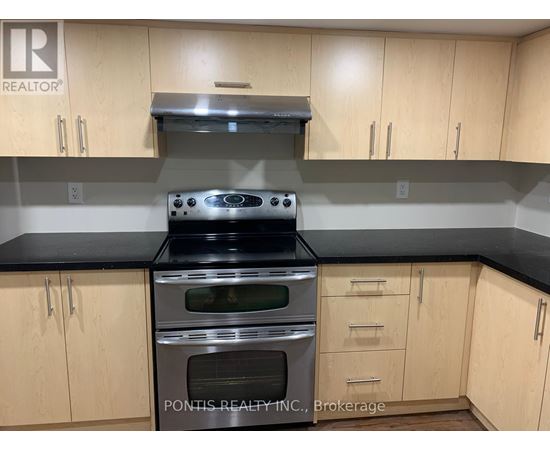 A kitchen with wooden cabinets and a stove top oven.