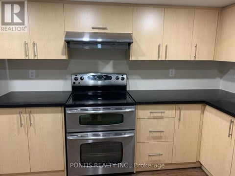 A kitchen with wooden cabinets and a stove top oven.
