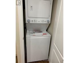 A white dryer and washer are in a small space.