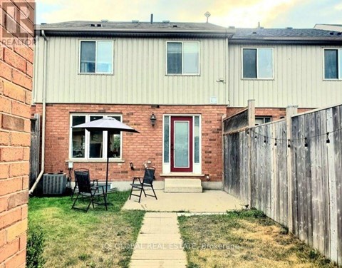 A house with a red door and a small patio area.