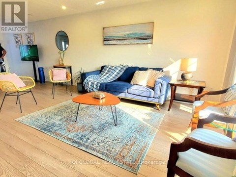 A living room with a blue sofa and a rug.
