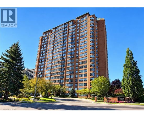 A tall building with a brown facade stands in front of a clear blue sky.