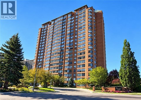 A tall building with a brown facade stands in front of a clear blue sky.
