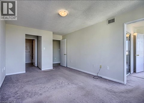 A spacious room with a carpeted floor and white walls.