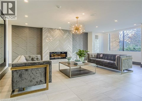 A well-lit living room with a grey sofa, a coffee table, and a chandelier.