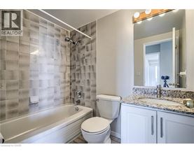 A bathroom with a tub, toilet and sink.