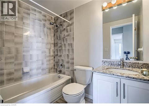 A bathroom with a tub, toilet and sink.