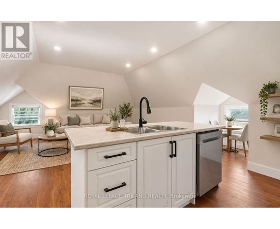 A kitchen with white cabinets and a wooden floor.