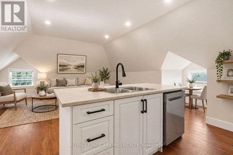 A kitchen with white cabinets and a wooden floor.