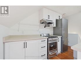 A kitchen with white cabinets and a stainless steel refrigerator.