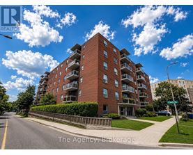 A street view of a red brick apartment building with a sign that says "The Agency Brokerage".