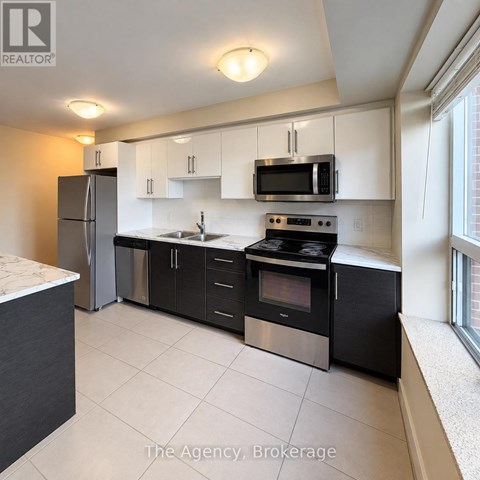 A kitchen with black appliances and white cabinets.