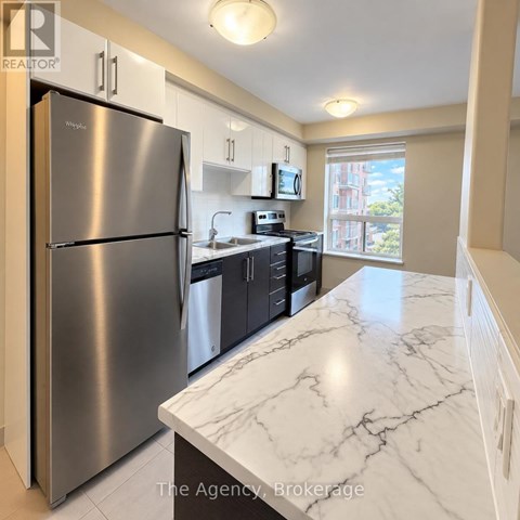 A kitchen with a marble counter top and stainless steel appliances.