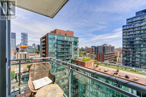 A balcony with a chair and a view of the city.