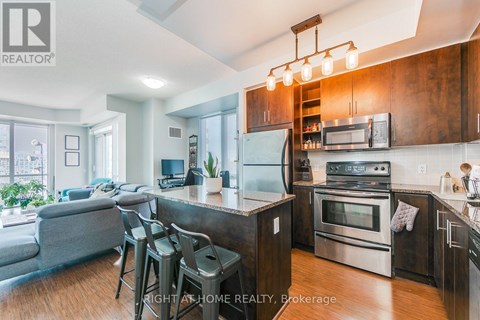 A modern kitchen with stainless steel appliances and wooden cabinets.