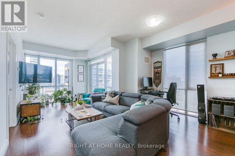 A living room with a grey couch and a wooden side table.