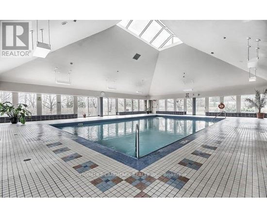 A large indoor swimming pool with a tiled floor.