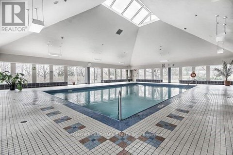 A large indoor swimming pool with a tiled floor.