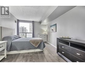 A bedroom with a bed, nightstand, and dresser.