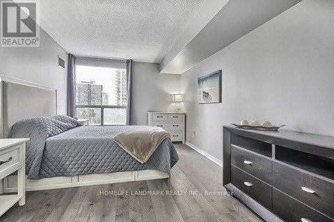 A bedroom with a bed, nightstand, and dresser.