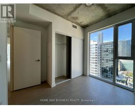 A room with a view of the city through large windows.